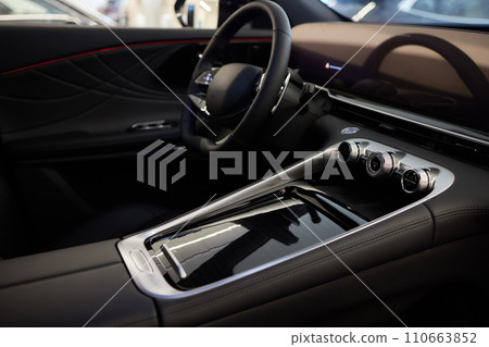 Selector automatic transmission with leather in the interior of a modern expensive car. The background is blurred. Black and brown leather car. Selector automatic transmission with leather in the interior of a modern expensive car. The background is blurred. Black and brown leather car. 110663852
