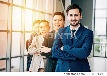 Confidence radiates from the group portrait of young businesspeople and a businessman indoors. With crossed arms, they represent a successful, diverse team and a thriving startup. Confidence radiates from the group portrait of young businesspeople and a businessman indoors. With crossed arms, they represent a successful, diverse team and a thriving startup. 110664399
