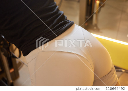 Close-up of a woman doing deadlift exercise alone at the gym. Close-up of a woman doing deadlift exercise alone at the gym. 110664492