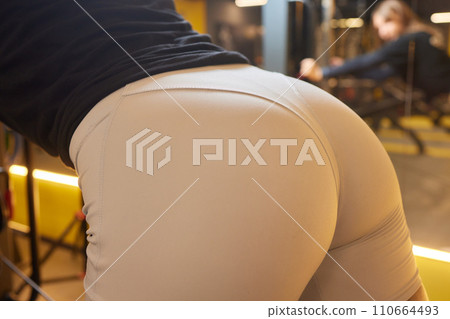 Close-up of a woman doing deadlift exercise alone at the gym. Close-up of a woman doing deadlift exercise alone at the gym. 110664493