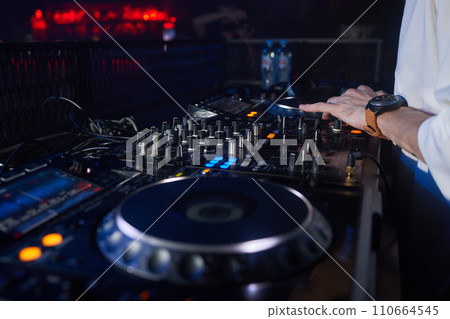 DJ is mixing music with deejay controller at outdoor summer pool or beach party - nightlife people lifestyle concept DJ is mixing music with deejay controller at outdoor summer pool or beach party - nightlife people lifestyle concept 110664545