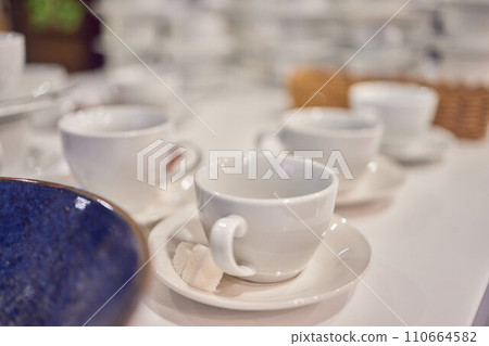 Close up of many empty white tea cups for company event hot beverage on tea time, catering and food service banquet preparations abstract concept 110664582