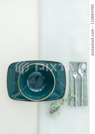 Above view of empty soup bowl with rectangular dish with cutlery on table 110664760