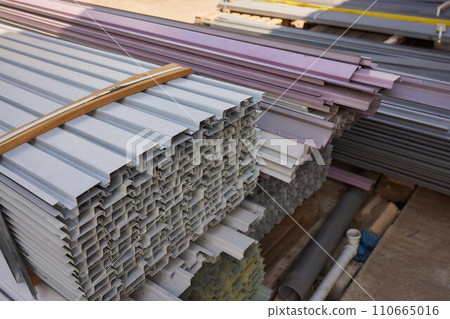 Scraps of rusty pipe of different sizes on rack in warehouse 110665016