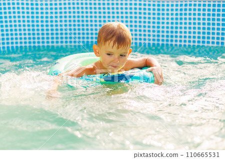 Boy Learning to Swim in Pool with Float Ring Boy Learning to Swim in Pool with Float Ring 110665531