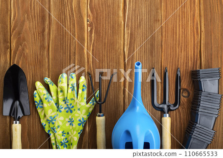 Gardening Tools and Gloves on Wooden Background Gardening Tools and Gloves on Wooden Background 110665533