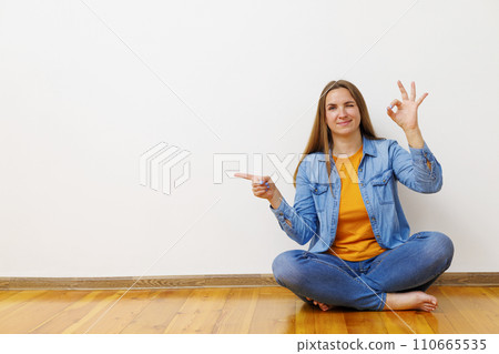 Content Woman Giving OK Sign and Pointing Side 110665535