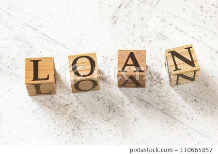 Four wooden cubes with word LOAN on white working board. Four wooden cubes with word LOAN on white working board. 110665857
