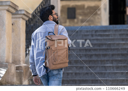 Young tall hindu man standing on the steps of an old building 110666249