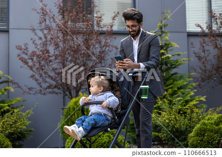 Dark-haired young businessman with a baby carriage outside 110666513