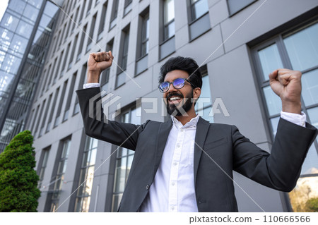 Waist up of an excited successful hindu businessman near the office building 110666566