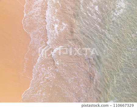 Top view beach with waves crashing on sandy shore,Beautiful waves sea surface in summer seascape background,Amazing beach colorful water background Top view beach with waves crashing on sandy shore,Beautiful waves sea surface in summer seascape background,Amazing beach colorful water background 110667329