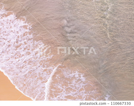 Top view beach with waves crashing on sandy shore,Beautiful waves sea surface in summer seascape background,Amazing beach colorful water background Top view beach with waves crashing on sandy shore,Beautiful waves sea surface in summer seascape background,Amazing beach colorful water background 110667330