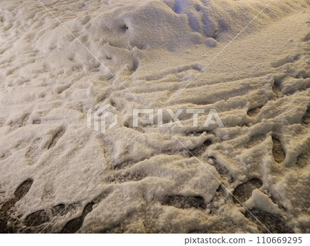 Winter snowy road with footprints 110669295