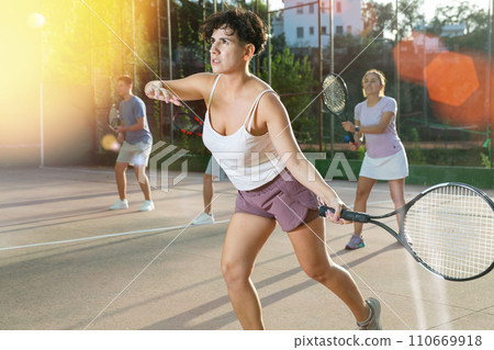 Young hispanic woman playing frontenis on open court in summer 110669918