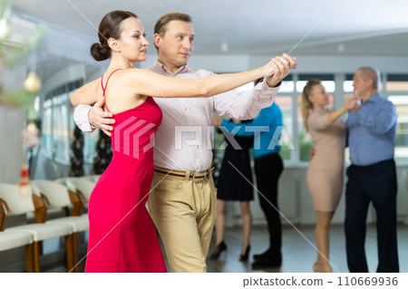 Woman learning to dance Vienneze waltz with man in dancing class Woman learning to dance Vienneze waltz with man in dancing class 110669936
