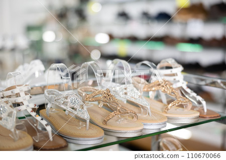 Womens sandals of latest summer collection are presented on glass window of store 110670066
