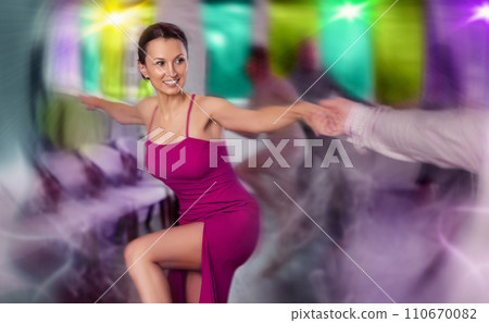 Cheerful brunette woman practicing vigorous dance in group dancing class 110670082
