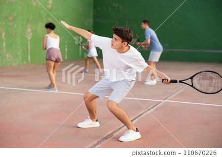 Young man serving ball during frontenis game outdoors 110670226