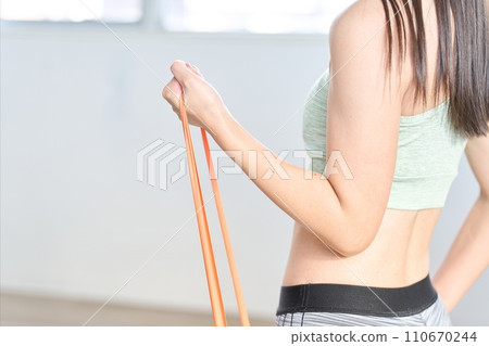 Woman doing arm training using resistance bands 110670244