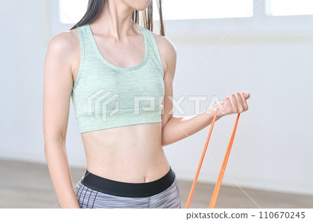 Woman doing arm training using resistance bands Woman doing arm training using resistance bands 110670245