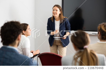 Knowledgeable female professor explaining subject to classroom full of students Knowledgeable female professor explaining subject to classroom full of students 110670448