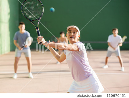 Woman playing frontenis on outdoor pelota court Woman playing frontenis on outdoor pelota court 110670461
