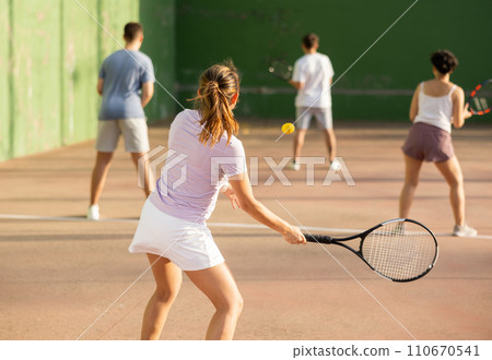 Rear view of young woman playing frontenis on outdoor fronton court 110670541