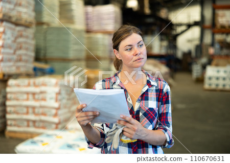 Woman checking quality of production at hardware store warehouse 110670631