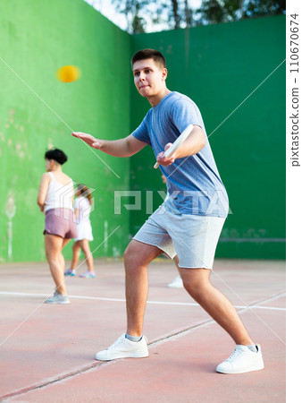 Concentrated young man paleta fronton player hitting ball with racket 110670674