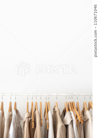 Hanger with neutral beige and white clothes on a white background. Hanger with neutral beige and white clothes on a white background. 110671046