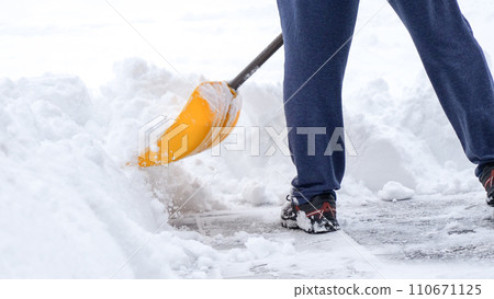 Man shoveling snow off of his driveway after a winter storm in Canada. Man with snow shovel cleans sidewalks in winter. Winter time. 110671125