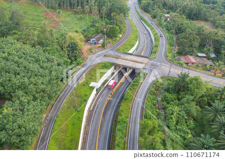 Aerial view of cars driving on highway or moterway. Overpass bridge street roads in connection network of architecture concept. Top view of forest trees. Nature landscape 110671174