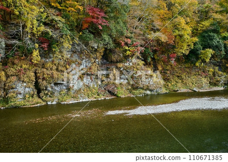 The flow of the Arakawa river and the Chichibu Red Cliffs with autumn leaves above Nagatoro Iwatatami The flow of the Arakawa river and the Chichibu Red Cliffs with autumn leaves above Nagatoro Iwatatami 110671385