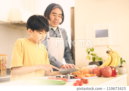 小學生在廚房做飯,一名中年男子在旁邊看著他們 小學生在廚房做飯,一名中年男子在旁邊看著他們 110671625