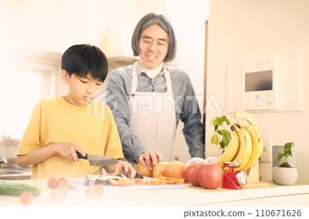 小學生在廚房做飯，一名中年男子在旁邊看著他們 110671626