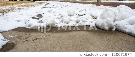 Residential sidewalk with section that has been cleared of snow next to a covered path. Residential sidewalk with section that has been cleared of snow next to a covered path. 110671974