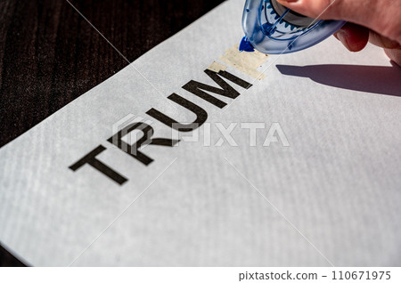 Correction tape being used to white out a paper with letters Correction tape being used to white out a paper with letters 110671975