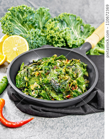 Kale cabbage with orange and pepper in pan on granite Kale cabbage with orange and pepper in pan on granite 110672369