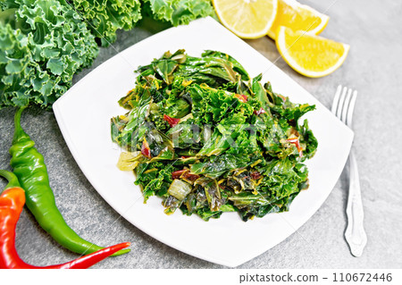 Kale cabbage with orange and pepper in plate on gray stone Kale cabbage with orange and pepper in plate on gray stone 110672446