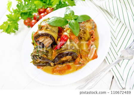 Rolls of eggplant with mincemeat in plate on white board Rolls of eggplant with mincemeat in plate on white board 110672489