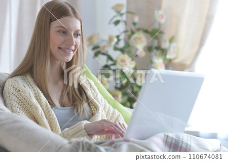Portrait of young woman using laptop at home 110674081