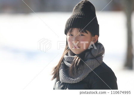 girl standing on a snowy field 110674995