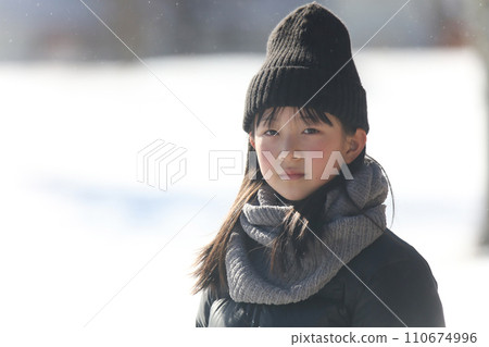 girl standing on a snowy field 110674996