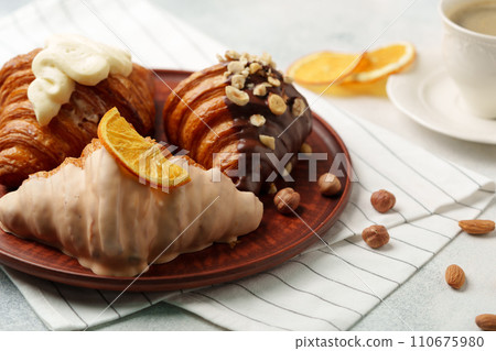 Glazed croissants on clay plate on table Glazed croissants on clay plate on table 110675980
