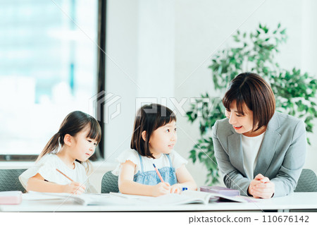 在補習班學習的小學生和老師。 在補習班學習的小學生和老師。 110676142