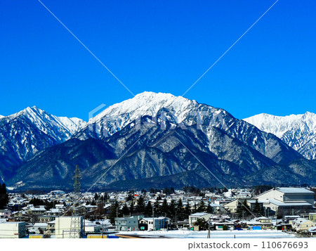 Snowy Omachi city and Northern Alps seen from a hill 110676693