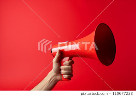 Generative AI A hand holds a red megaphone on a red background Generative AI A hand holds a red megaphone on a red background 110677228