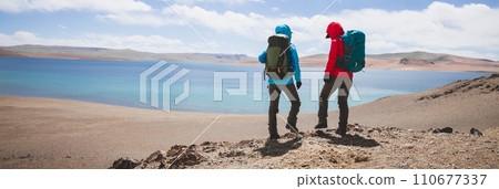 Two women backpackers hiking in beautiful winter high altitude mountains 110677337