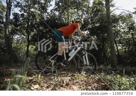 Mountain biking on spring forest trail Mountain biking on spring forest trail 110677359